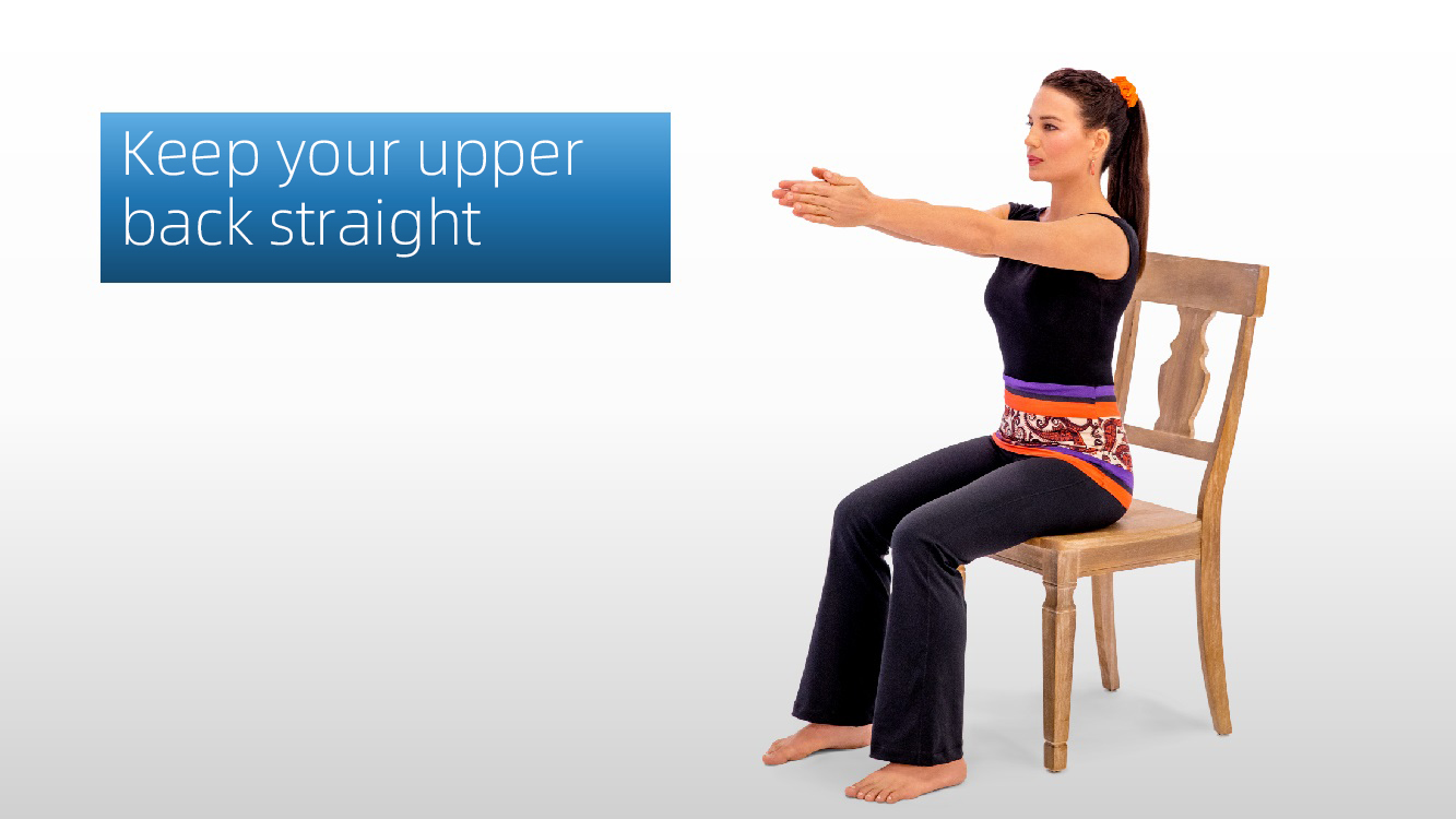 Woman seated on a chair with arms extended forward, demonstrating correct straight-back posture for Flapping Wings exercise