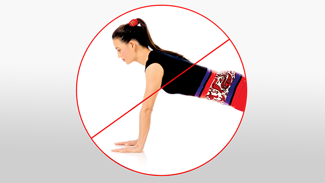 Prohibition symbol over a woman doing Toes and Palms Balance exercise, indicating this should be avoided with diastasis recti